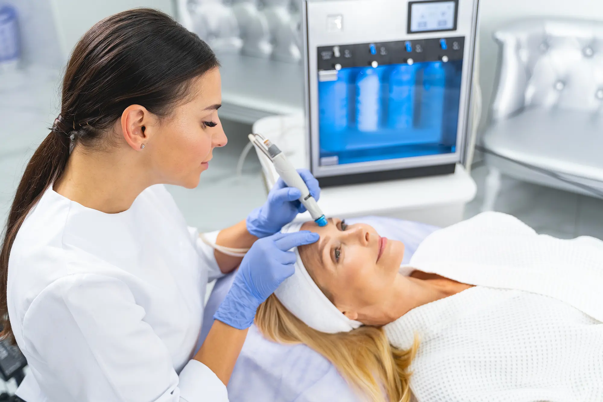 nurse performing microneedling on a woman