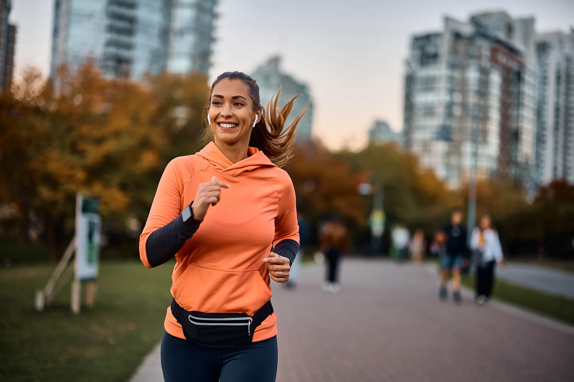 woman in neon orange shirt running in the city